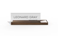 a wooden business card holder with a name tag on the front, and a white background