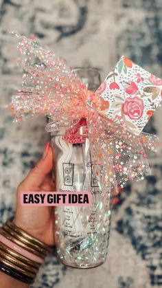 a hand holding a mason jar with pink and white flowers on it that says easy gift idea