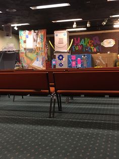 an empty church pews with posters on the wall behind them and other decorations hanging from the ceiling