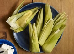 corn on the cob with butter and garlic in a blue bowl next to it