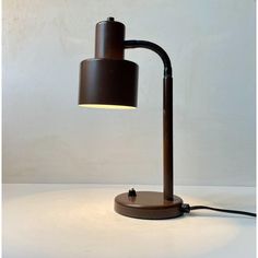 a lamp that is sitting on top of a table next to a white wall and floor