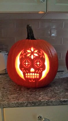 two carved pumpkins sitting on top of a kitchen counter