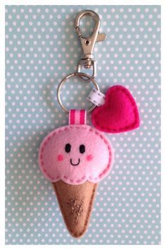 a pink ice cream keychain with a smiling face on it and a heart hanging from the front