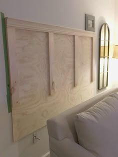 a white couch sitting under a wooden headboard