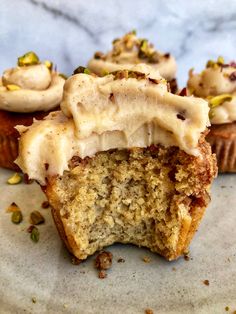 some cupcakes with frosting and pistachio sprinkles