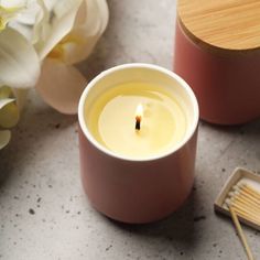 a small candle sitting on top of a table next to a container with matchesticks