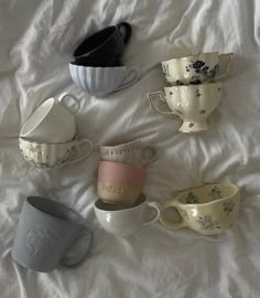 five coffee cups are lined up on a bed