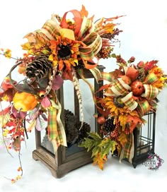 a lantern decorated with fall leaves and pine cones