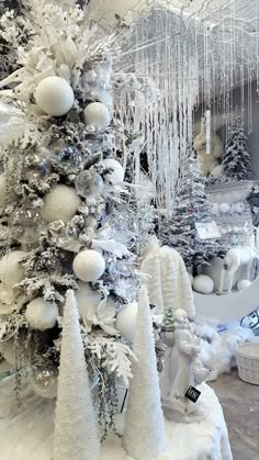 the snow covered trees are decorated with white ornaments