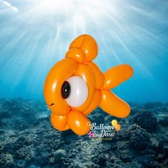 an orange balloon shaped like a fish floating on the ocean floor with sunbeams in the background