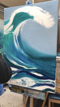 a painting being worked on by someone in the process of making it look like an ocean wave