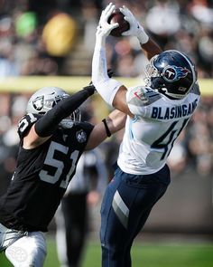 two football players are jumping up to catch the ball