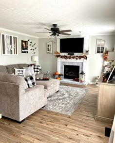 a living room filled with furniture and a flat screen tv mounted on the wall above a fire place