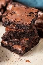 three chocolate brownies stacked on top of each other with one bite taken out of it