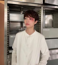 a young man standing in front of an oven