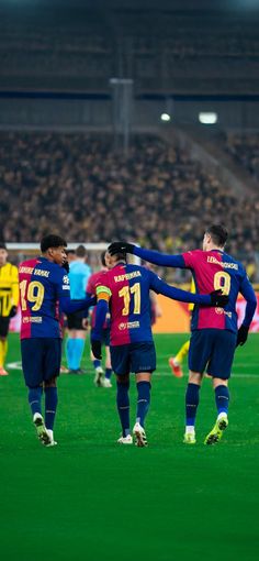 the soccer players are congratulating each other on the field in front of an audience