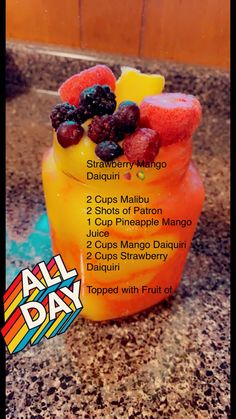 a cup filled with fruit sitting on top of a counter next to a sign that says all day