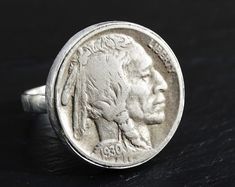 an old silver buffalo coin ring on a black surface