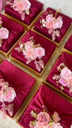 many pink flowers are placed on red velvet boxes with gold trimmings and beading