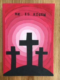 a painting with the words he is risen and three crosses in front of a pink background