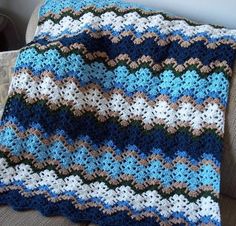 a crocheted blanket sitting on top of a couch