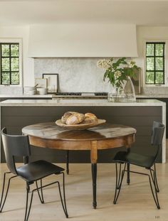 a table with some bread on top of it in front of a kitchen countertop