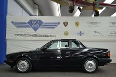 a black car parked in front of a wall