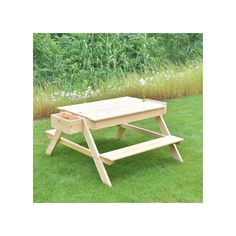 a wooden picnic table sitting in the grass