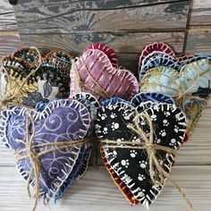 four heart shaped ornaments tied together with twine on wooden planked wall behind them