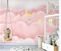 a child's bedroom with pink clouds and stars on the wall, an elephant swinging from a swing