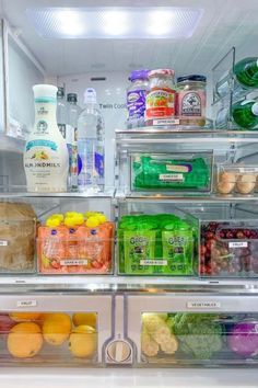 an open refrigerator filled with lots of different types of drinks and food in plastic containers