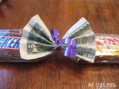 a bow made out of money sitting on top of a wooden table