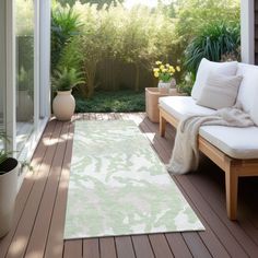 a white rug on top of a wooden floor next to a couch and potted plants