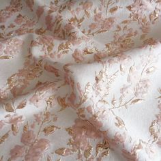 a pink and gold floral print on white fabric