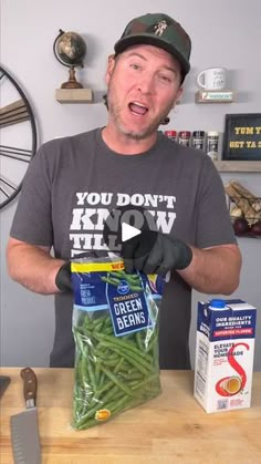 a man holding up a bag of green beans