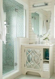 a bathroom with a sink, mirror and shower stall