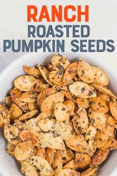 roasted pumpkin seeds in a white bowl with text overlay that reads ranch roasted pumpkin seeds