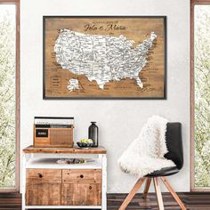 a wooden united states map hanging on the wall in a room with a black chair