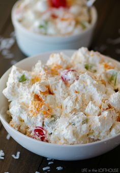 two white bowls filled with food on top of a wooden table