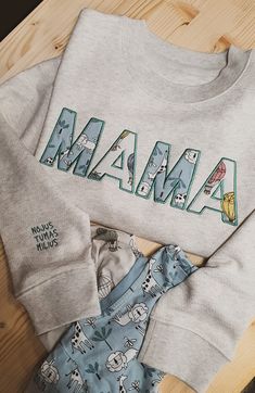 pajamas and onesuits laid out on a wooden floor with the word mama printed on them