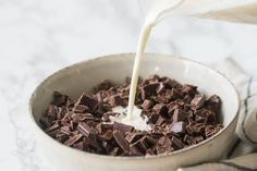 milk being poured into a bowl filled with chocolate chips