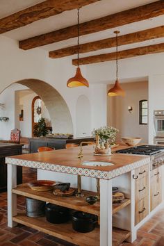 a kitchen with an island in the middle of it and two lights hanging from the ceiling