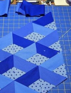 the blue fabric is being sewn together to make an origami star quilt