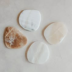 three pieces of white marble sitting on top of a table