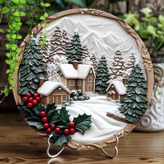 a christmas scene on a plate sitting on a table next to a potted plant