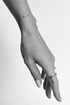 a woman's hand with a small tattoo on it