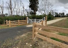 a wooden fence next to a dirt road