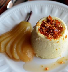 a dessert on a white plate with caramel and pecans in the middle next to it