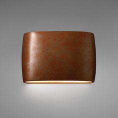 a light fixture on the wall with a brown surface and an orange rectangular shaped shade