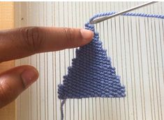 someone is knitting a triangle in blue yarn